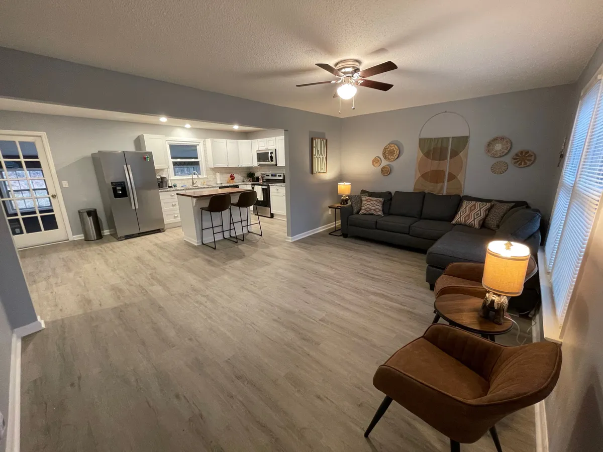 This image captures the open-plan layout that seamlessly connects the kitchen, dining area, and living space. The dining area is visible alongside the kitchen island, with inviting lighting and decor that encourage communal meals and relaxed gatherings.